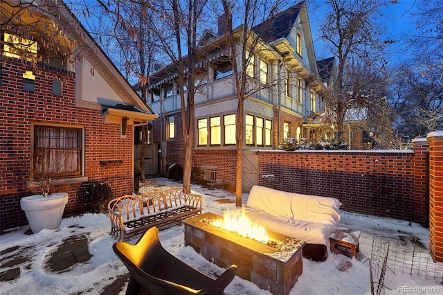 snow covered patio featuring an outdoor fire pit