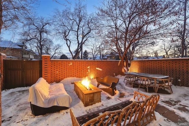 snow covered patio with a fire pit