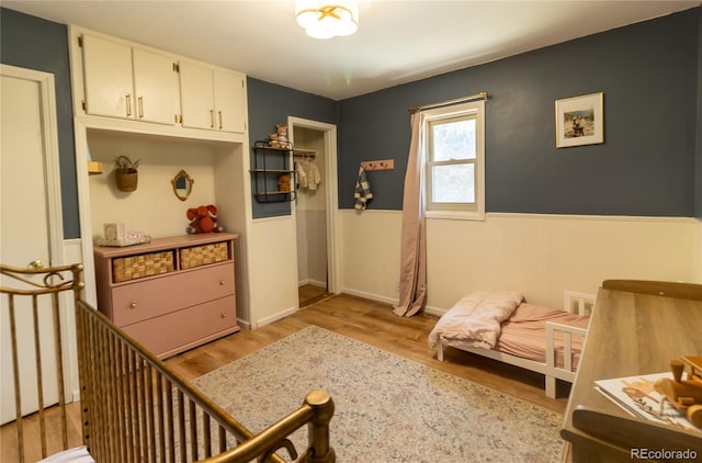 2795 SE Grapevine Rd, Idledale, CO 80453 - bedroom with light wood-style flooring and a wainscoted wall