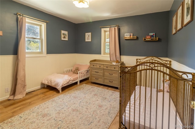 2795 SE Grapevine Rd, Idledale, CO 80453 - bedroom with a wainscoted wall and wood finished floors