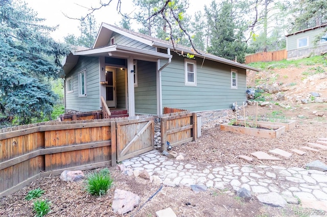 2795 SE Grapevine Rd, Idledale, CO 80453 - view of front of property featuring fence, a gate, and a vegetable garden