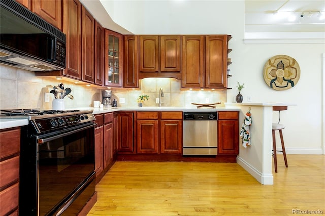 1140 Columbine St Unit 302, Denver, CO 80206 - kitchen featuring black appliances, light countertops, glass insert cabinets, and light wood-type flooring