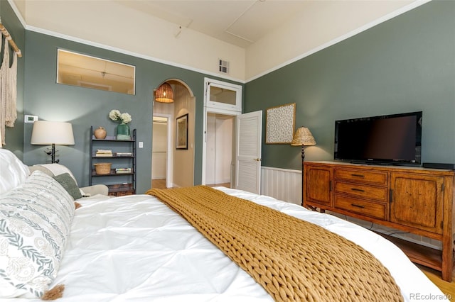 1140 Columbine St Unit 302, Denver, CO 80206 - bedroom with arched walkways, a wainscoted wall, and wood finished floors