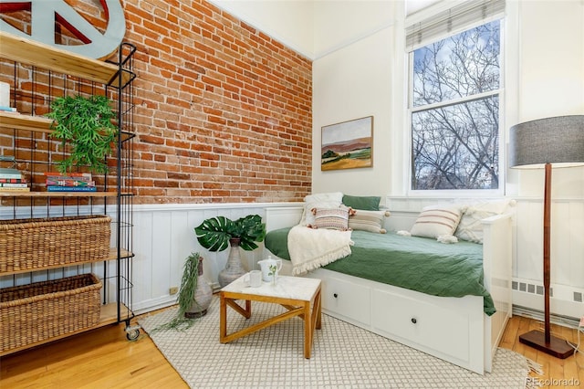 1140 Columbine St Unit 302, Denver, CO 80206 - bedroom featuring wainscoting, wood finished floors, and brick wall