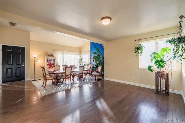 dining room featuring vaulted ceiling, baseboards, and hardwood / wood-style flooring