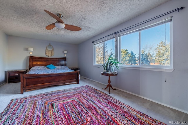 carpeted bedroom with baseboards, a textured ceiling, and ceiling fan