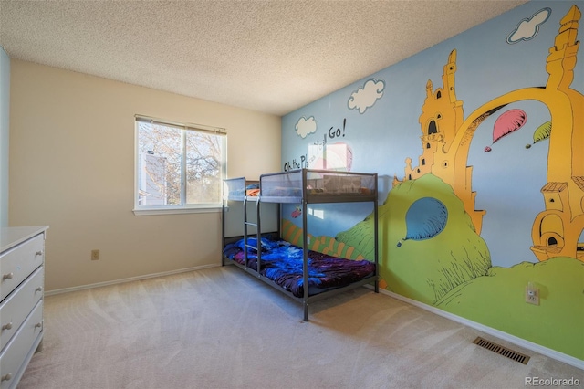 bedroom with baseboards, visible vents, carpet floors, and a textured ceiling