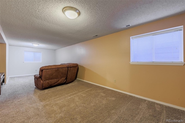 unfurnished room with visible vents, baseboards, carpet, and a textured ceiling