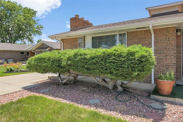 4705 Upham St, Wheat Ridge, CO 80033 - view of property exterior with a chimney and brick siding