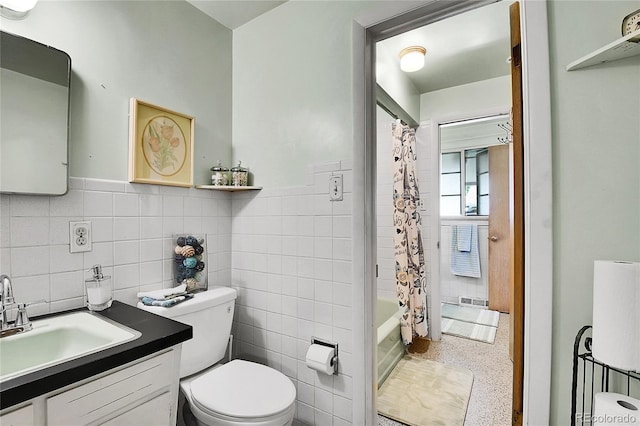 4705 Upham St, Wheat Ridge, CO 80033 - full bathroom with tile walls, vanity, speckle patterned floor, a wainscoted wall, and shower / bathtub combination with curtain