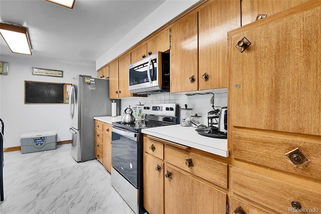 4705 Upham St, Wheat Ridge, CO 80033 - kitchen featuring appliances with stainless steel finishes, light countertops, tasteful backsplash, brown cabinetry, and light marble finish flooring