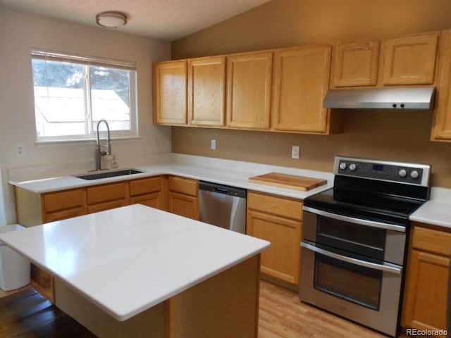 kitchen featuring sink, appliances with stainless steel finishes, light brown cabinetry, vaulted ceiling, and light wood-type flooring