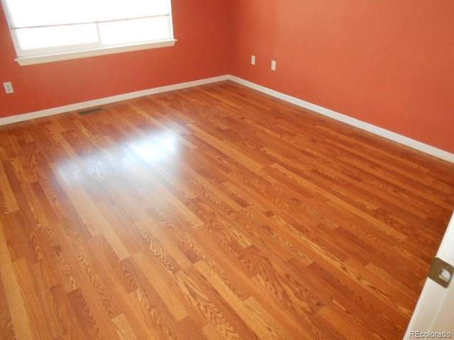 empty room with hardwood / wood-style flooring