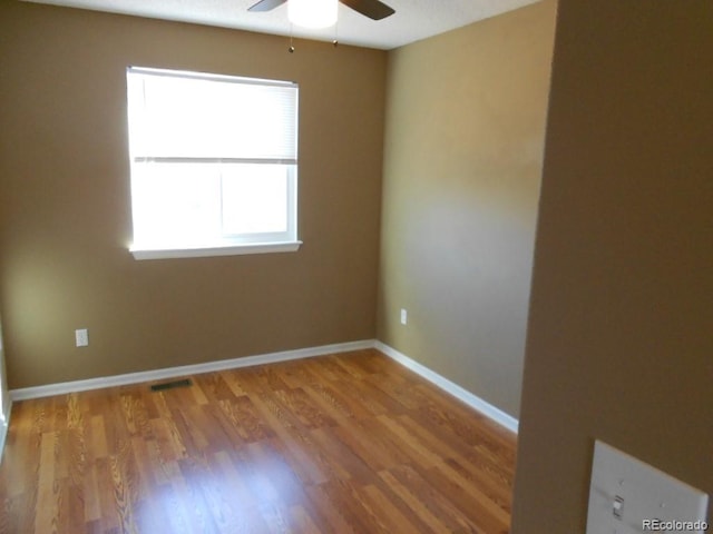 empty room with hardwood / wood-style floors and ceiling fan