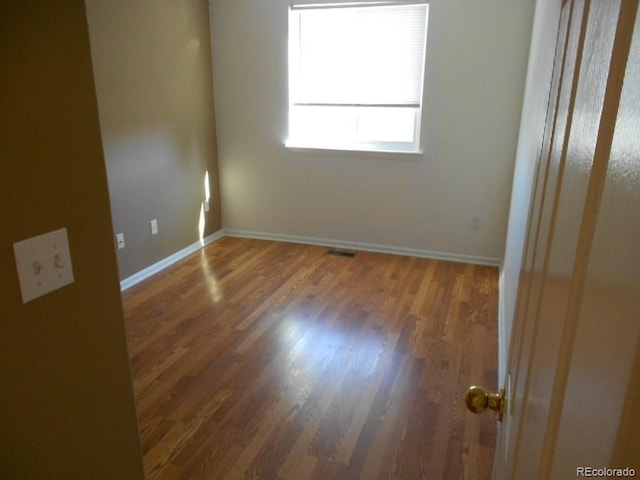 spare room with hardwood / wood-style flooring