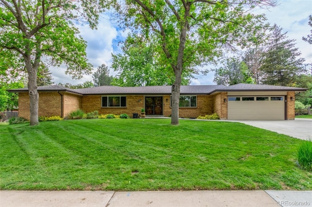 5890 W Quarles Dr, Littleton, CO 80128 - view of front of home with an attached garage, driveway, brick siding, and a front lawn