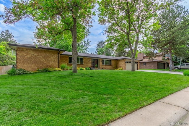 5890 W Quarles Dr, Littleton, CO 80128 - view of front of home with an attached garage, concrete driveway, brick siding, and a front lawn