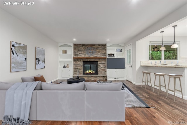 5890 W Quarles Dr, Littleton, CO 80128 - living area with dark wood-style floors, recessed lighting, a fireplace, baseboards, and built in shelves