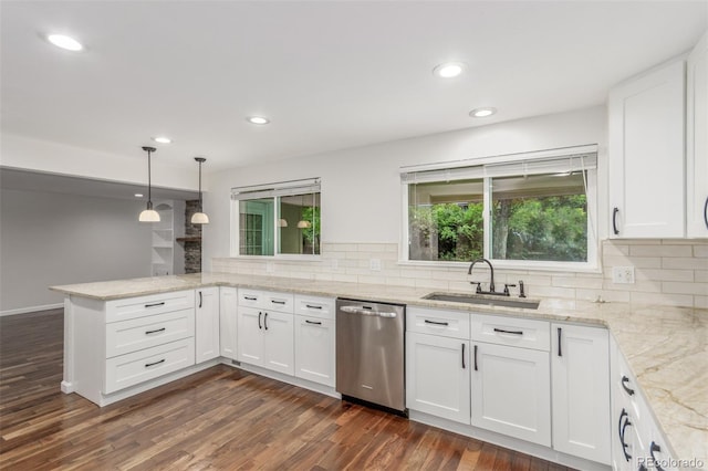 5890 W Quarles Dr, Littleton, CO 80128 - kitchen with stainless steel dishwasher, a sink, a peninsula, white cabinets, and tasteful backsplash