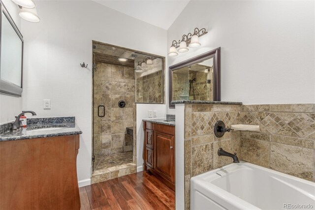 5890 W Quarles Dr, Littleton, CO 80128 - full bath with a stall shower, wood finished floors, vanity, and a garden tub