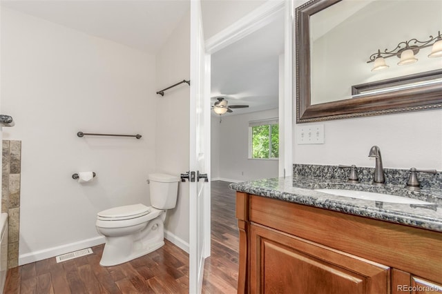 5890 W Quarles Dr, Littleton, CO 80128 - full bath with vanity, toilet, baseboards, wood finished floors, and a tub to relax in