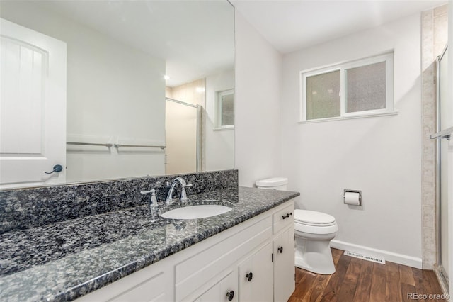 5890 W Quarles Dr, Littleton, CO 80128 - full bathroom featuring a shower stall, baseboards, vanity, toilet, and wood finished floors