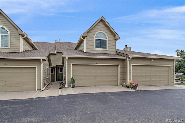 10389 W Fair Ave Unit E, Littleton, CO 80127 - view of property featuring a shingled roof and a chimney