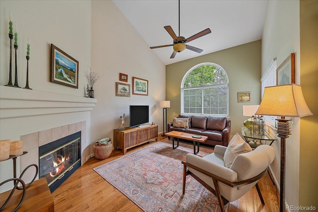 10389 W Fair Ave Unit E, Littleton, CO 80127 - living area with ceiling fan, a tiled fireplace, wood finished floors, and lofted ceiling