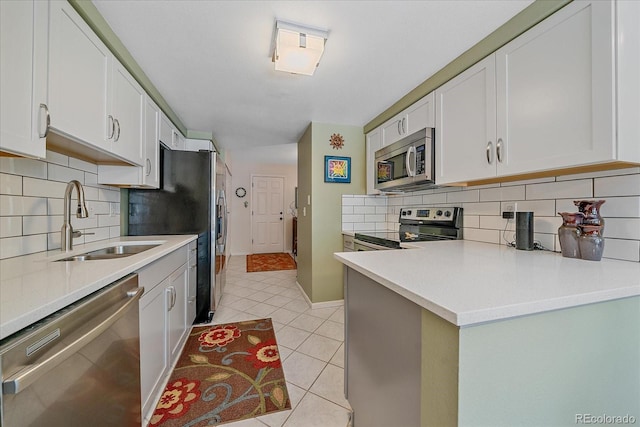 10389 W Fair Ave Unit E, Littleton, CO 80127 - kitchen with appliances with stainless steel finishes, a sink, tasteful backsplash, and white cabinets