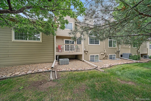 10389 W Fair Ave Unit E, Littleton, CO 80127 - back of property with a wooden deck, central AC, and a lawn