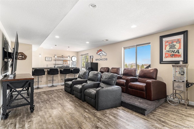living room featuring a textured ceiling, wood finished floors, and recessed lighting
