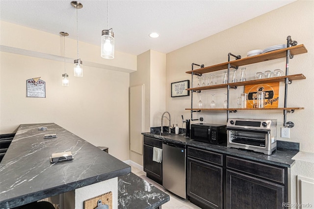 kitchen featuring dark cabinets, refrigerator, a toaster, black microwave, and a sink