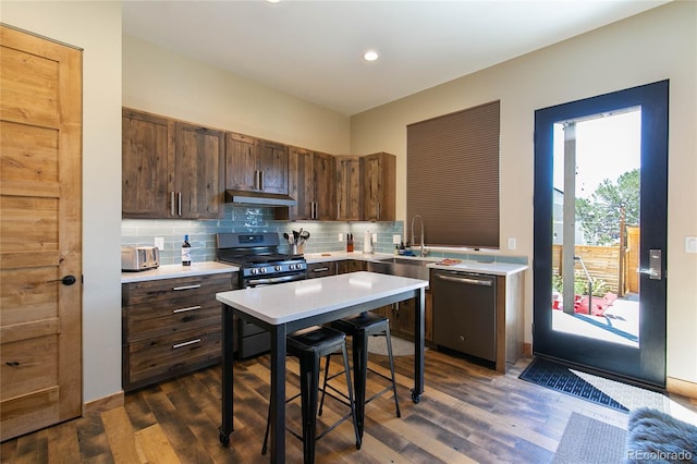467 E Arkansas St, Buena Vista, CO 81211 - kitchen with appliances with stainless steel finishes, under cabinet range hood, light countertops, backsplash, and dark wood-style flooring