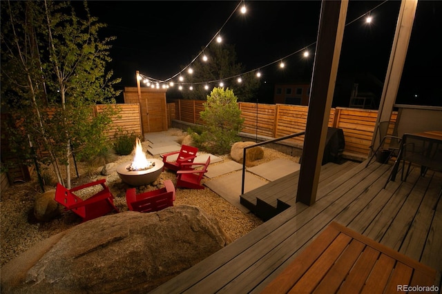 467 E Arkansas St, Buena Vista, CO 81211 - deck at night with an outdoor fire pit and a fenced backyard