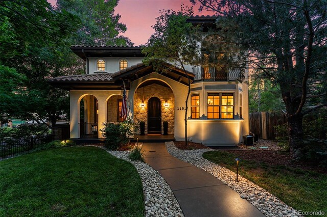 mediterranean / spanish-style home with a yard and a balcony