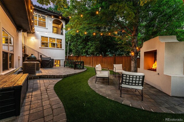 view of yard with a patio area, exterior fireplace, and central AC unit