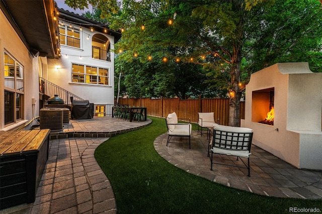 view of yard featuring a patio area, an outdoor living space with a fireplace, and central AC