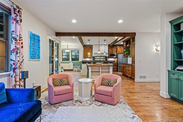 living room with light wood-type flooring and beamed ceiling