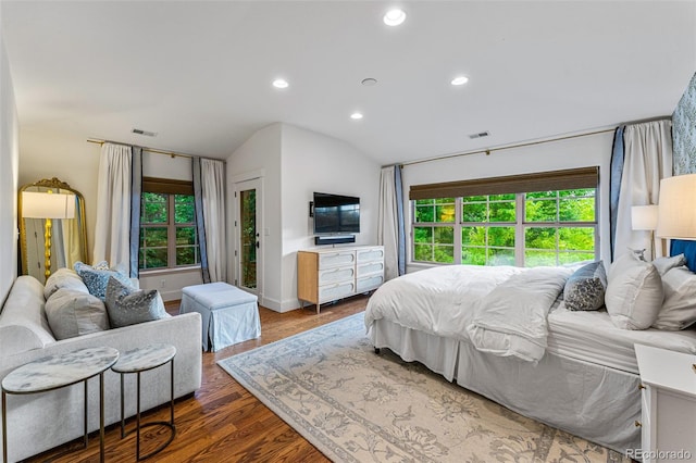 bedroom with hardwood / wood-style flooring, vaulted ceiling, and multiple windows