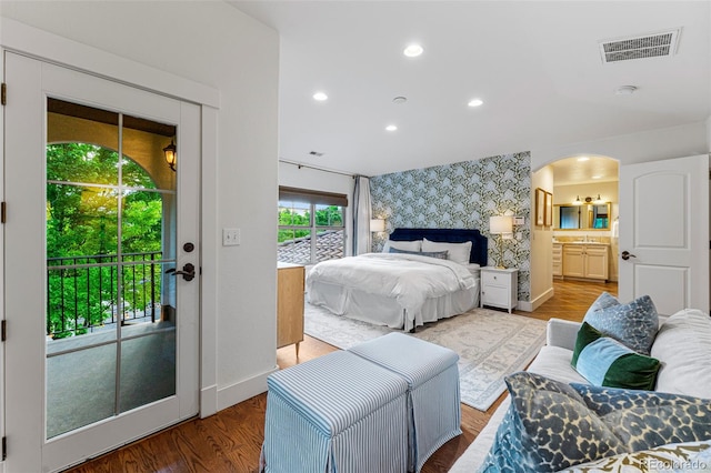 bedroom featuring access to exterior, ensuite bath, and wood-type flooring