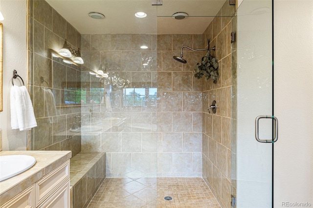 bathroom with a shower with shower door and vanity