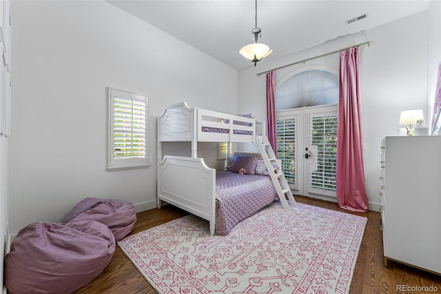 bedroom featuring dark wood-type flooring, multiple windows, access to exterior, and french doors