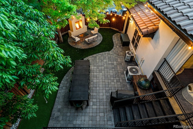 view of patio with a fireplace and central AC unit