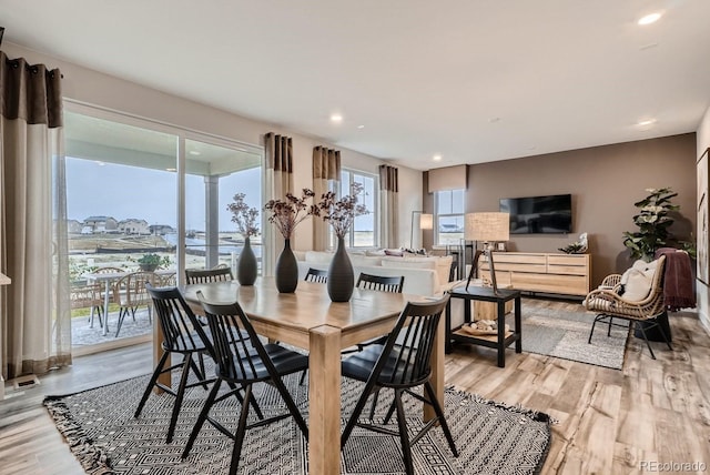 dining space with recessed lighting and light wood-type flooring