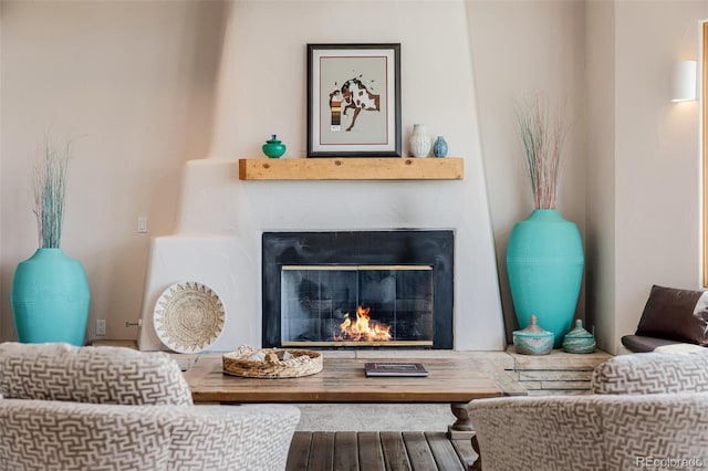 living area featuring a glass covered fireplace and wood finished floors