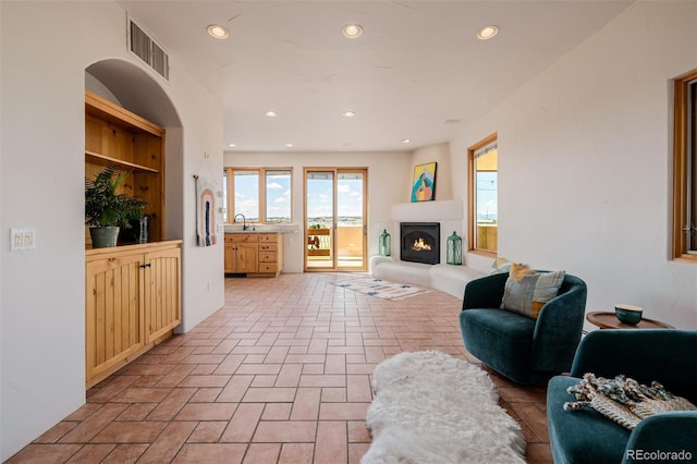 living area with recessed lighting and a glass covered fireplace