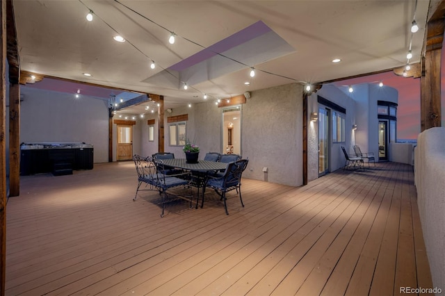 wooden deck with outdoor dining area and a hot tub