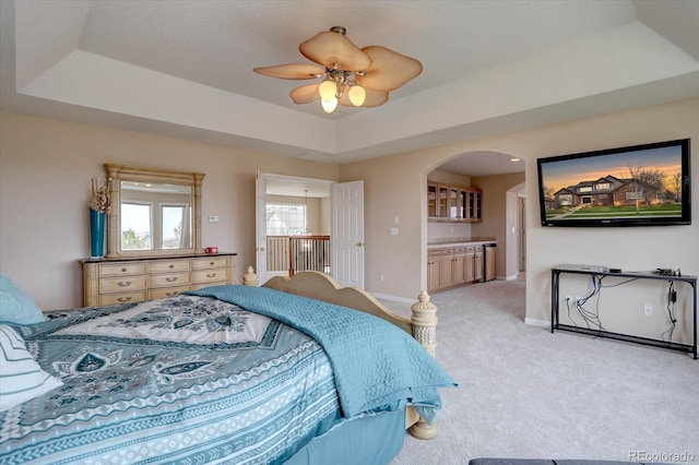 15857 E Aberdeen Ave, Centennial, CO 80016 - bedroom featuring arched walkways, light carpet, a tray ceiling, baseboards, and a ceiling fan