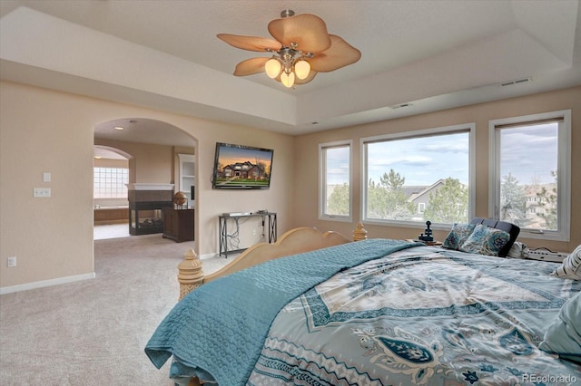 15857 E Aberdeen Ave, Centennial, CO 80016 - bedroom featuring arched walkways, light colored carpet, baseboards, and a tray ceiling