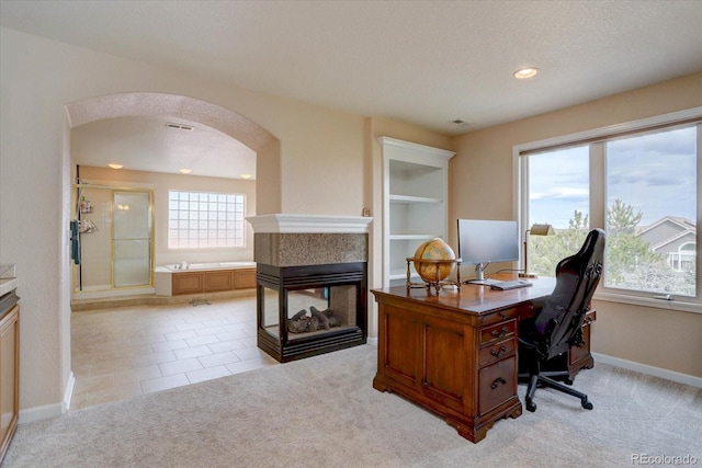 15857 E Aberdeen Ave, Centennial, CO 80016 - office area featuring arched walkways, light colored carpet, a multi sided fireplace, baseboards, and recessed lighting